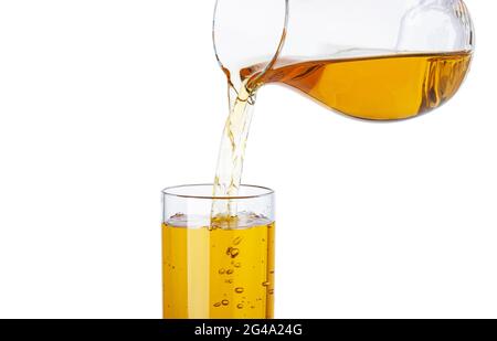 Apfelsaft, der aus dem Krug in ein isoliertes Glas auf weißem Hintergrund gießt Stockfoto