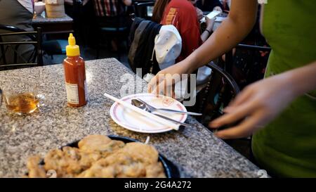 Essen gastfreundlich im Restaurant in Chinatown Bangkok Thailand Essen auf dem Teller gebratene Austern Kellnerin am Arbeitsplatz Reinigungstisch Stockfoto