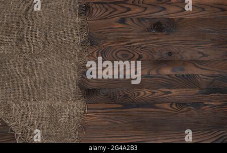 Alte sackleinen Stoff Serviette auf braun Holz- Hintergrund, Ansicht von oben Stockfoto