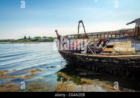 Fischerboot Wracks in Salen, auf der Isle of Mull. Der Sound of Mull ist im Hintergrund. Schottland, August 2019. Stockfoto