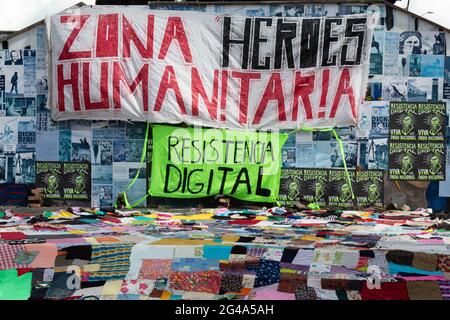 Zeichen mit der Aufschrift „Heroes Monument Humanitarian Zone“ beim Konzert Arte Unido x Colombia im Monumento a los Heroes führten mehrere Künstler der städtischen Musik und Mc's verschiedene Aktivitäten wie Drucke, Graffiti und ein Gemeinschaftstopf mit der Absicht, sich zu vereinen, um den Nationalstreik „Paro Nacional“ in Bogota, Kolumbien, am 19. Juni 2021 zu unterstützen. Stockfoto