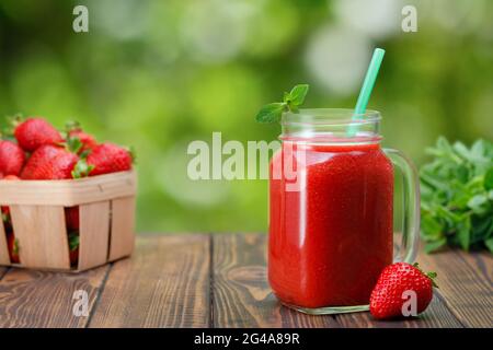 Erdbeer-Smoothie im Glas-Einmachglas im Freien Stockfoto