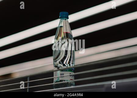 Wenige Flaschen mit Trinkwasser im Regal im Kaufhaus, Mangel an Waren Stockfoto