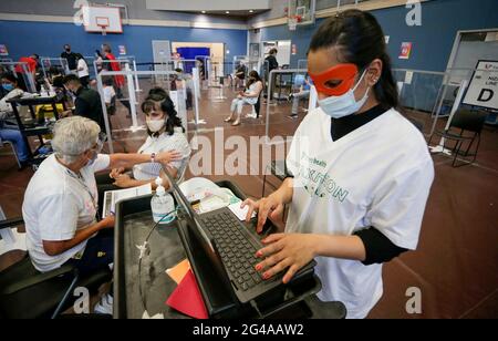 Surrey, Kanada. Juni 2021. Gesundheitshelfer, die Maskeraden tragen, werden während einer „Vax-a-thon“-Veranstaltung im Surrey's Guildford Recreation Center in Surrey, British Columbia, Kanada, am 19. Juni 2021 gesehen. Die 32-stündige Non-Stop-Veranstaltung „Vax-a-thon“ wurde hier am Samstag mit dem Ziel abgehalten, 7,000 Personen für ihre erste Dosis von COVID-19-Impfstoffen zu impfen. Quelle: Liang Sen/Xinhua/Alamy Live News Stockfoto
