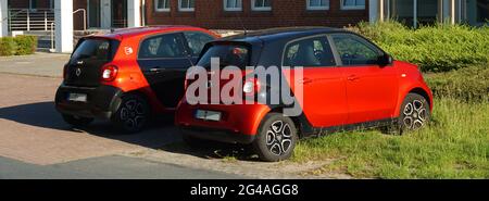 Neuenhaus, Niedersachsen, Deutschland - Juni 16 2021 zwei schwarz-rote Smart forfour Autos parkten nebeneinander. Sie sind beide in der zweiten Generation. Stockfoto