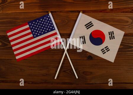 Die Flagge der USA und die Flagge Südkoreas kreuzten sich. USA vs. Südkorea. Das Bild veranschaulicht die Beziehung zwischen den Ländern. Fotografie Stockfoto