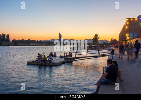 Wien, Wien: Sonnenuntergang am Copa Beach an der Neuen Donau, Menschen am Ufer, Restaurant Rembetiko, Millennium Tower 22. Donaust Stockfoto