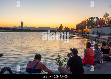 Wien, Wien: Sonnenuntergang am Copa Beach an der Neuen Donau, Menschen am Ufer, Restaurant Rembetiko, Millennium Tower 22. Donaust Stockfoto