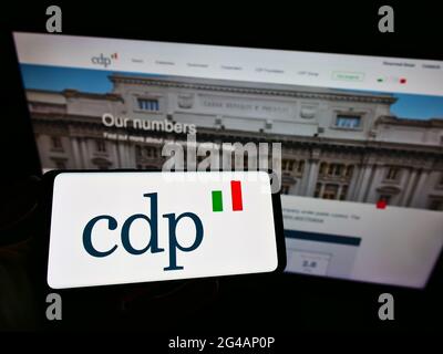 Person mit Mobiltelefon und Logo der italienischen Bank Cassa Depositi e Prestiti (CDP) auf dem Bildschirm vor der Business-Webseite. Konzentrieren Sie sich auf die Telefonanzeige. Stockfoto