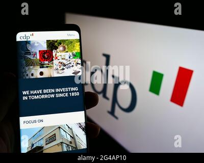 Person mit Smartphone und Website der italienischen Bank Cassa Depositi e Prestiti Spa (CDP) auf dem Bildschirm mit Logo. Konzentrieren Sie sich auf die Mitte des Telefondisplays. Stockfoto