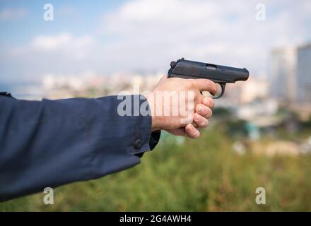 Mann Hand hält Waffe. Selektiver Fokus mit geringer Schärfentiefe. Stockfoto
