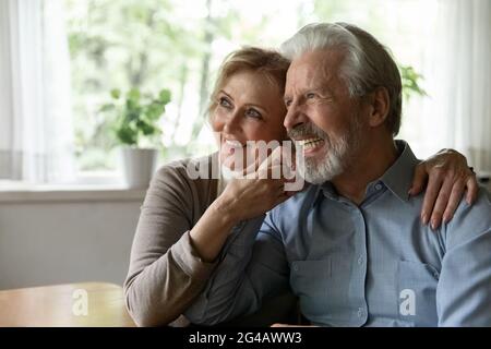 Lächelndes altes Paar umarmt und träumt von einer gesunden Zukunft Stockfoto