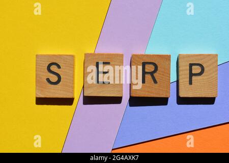 SERP, Akronym für Search Engine Results Page in hölzernen Buchstaben auf mehrfarbigem Hintergrund Stockfoto
