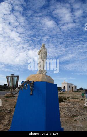 MARSAXLOKK, MALTA - 01 JAN, 2020: Kapelle der Unbefleckten Empfängnis mit Statue im Vordergrund an der felsigen Küste von Malta Stockfoto