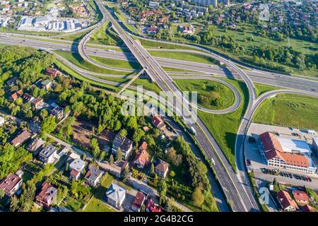 Autobahnkreuz auf mehreren Ebenen. Spaghetti-Kreuzung auf der internationalen Autobahn A4, dem Teil der Kreisstraße um Krakau, Polen. Luftaufnahme im Frühjahr Stockfoto