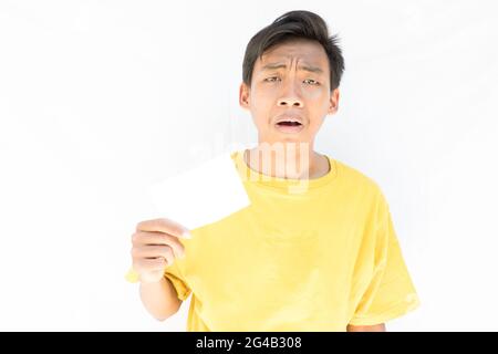Ein Indonesier mit einem Stück Papier, der auf die Kamera schaute und fast auf weißem Hintergrund weinte Stockfoto