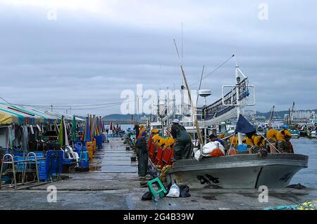 20. Juni 2021-Kosong, Südkorea-in Dieses Foto wurde am 13. Juni 2003 aufgenommen. Fischermänner, die am frühen Morgen im Fischereihafen im Hafen von Keojin, Kosong, Südkorea, arbeiteten. Kosong County in der Provinz Kangwon, Nordkorea. Sie liegt in der südlichsten Ecke Nordkoreas, unmittelbar nördlich der demilitarisierten Zone Koreas. Vor dem Ende des Koreakrieges im Jahr 1953 bildete sie zusammen mit der heutigen südkoreanischen Grafschaft mit dem gleichen Namen eine einzige Grafschaft. Bei einer anschließenden Reorganisation nahm der Landkreis den südlichen Teil des Landkreises Tongchon auf. Stockfoto