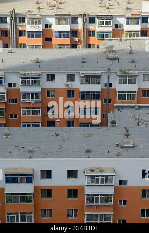 Älteres Apartmentgebäude, umgeben von neueren Apartmentgebäuden, Büros und Hotels im Zentrum von Shenyang, China Stockfoto