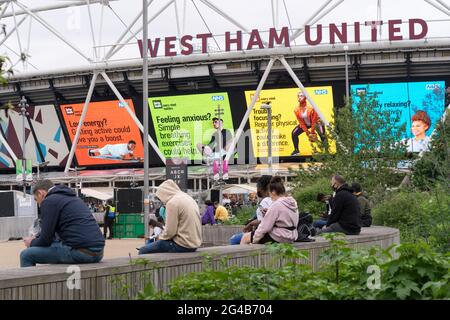 Geimpfte Personen sitzen vor dem Impfzentrum Covid-19 im Olympiastadion Stratford, East London, England, Großbritannien, Super Saturday Stockfoto