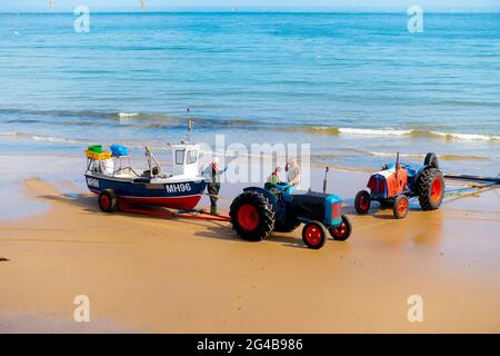 Krabbe oder Hummer, Fischer, die einen Traktor fahren, der ihr Boot aus dem Meer schleppt, halten an, um mit einem anderen Fischer Redcar Cleveland UK zu plaudern Stockfoto