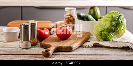 Lebensmittelbanner. Leckeres und gesundes Gemüse. Küchenzubehör. Schneiden von Holzbrettern und Utensilien. Reife Tomaten, frische Gurken und knuspriges Eis Stockfoto