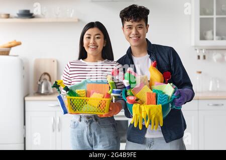 Porträt von lächelnden asiatischen Haushaltern mit Reinigungsmitteln Stockfoto