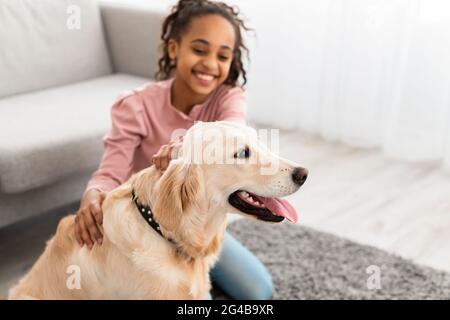 Junge schwarze Mädchen mit Spaß mit Hund zu Hause Stockfoto