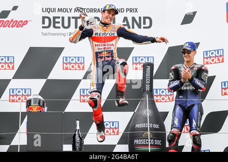 Hohenstein Ernstthal, Deutschland. Juni 2021. Motorsport/Motorrad, großer Preis von Deutschland, MotoGP auf dem Sachsenring: Fahrer Marc Marquez aus Spanien vom Repsol Honda Team feiert seinen Sieg bei der Siegerehrung. Neben ihm Fabio Quartararo aus Frankreich vom Monster Energy Yamaha MotoGP Team. Quelle: Jan Woitas/dpa-Zentralbild/dpa/Alamy Live News Stockfoto