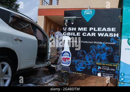 18. Juni 2021, Nairobi, Kiambu County, Kenia: Ein Mitarbeiter von Wash Me Please Mobile Carwash verwendet eine Autowaschmaschine, die in einem elektrischen Tuk Tuk installiert ist, um ein Auto im Haus eines Kunden in Kiambu zu reinigen.die Wash Me please ist ein kenianisches Startup-Unternehmen, das bequeme mobile Autowaschdienste bequem von zu Hause aus oder anbietet Arbeitsplatz als eine Möglichkeit, die Ausbreitung von Covid-19 zu bekämpfen. Wash Me Please ist Detailing and Carwash Company, die zu Beginn der Pandemie von Covid-19 gegründet wurde. Sie bieten ihren Kunden mobile Autowaschdienste über eine mobile App an, mit der sie ihren Service anfordern können Stockfoto