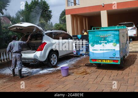 18. Juni 2021, Nairobi, Kiambu County, Kenia: Ein Mitarbeiter von Wash Me Please Mobile Carwash verwendet eine Autowaschmaschine, die in einem elektrischen Tuk Tuk installiert ist, um ein Auto im Haus eines Kunden in Kiambu zu reinigen.die Wash Me please ist ein kenianisches Startup-Unternehmen, das bequeme mobile Autowaschdienste bequem von zu Hause aus oder anbietet Arbeitsplatz als eine Möglichkeit, die Ausbreitung von Covid-19 zu bekämpfen. Wash Me Please ist Detailing and Carwash Company, die zu Beginn der Pandemie von Covid-19 gegründet wurde. Sie bieten ihren Kunden mobile Autowaschdienste über eine mobile App an, mit der sie ihren Service anfordern können Stockfoto