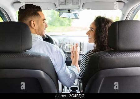 Liebevolles Paar, das sich die Hände hält, während es im Auto sitzt Stockfoto
