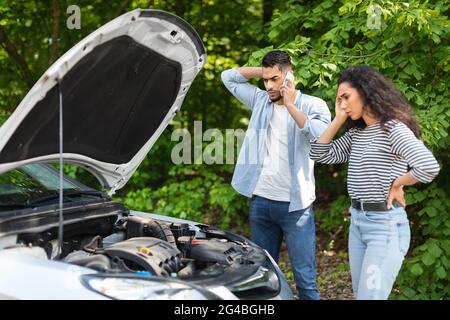 Junger arabischer Mann ruft am Telefon um Hilfe, Autopause Stockfoto