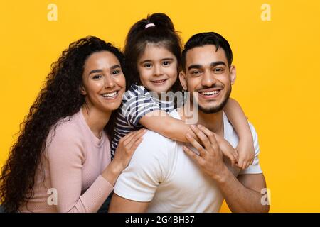 Porträt Einer Fröhlichen Arabischen Familie Mit Tochter, Die Die Kamera Umarmt Und Lächelt Stockfoto