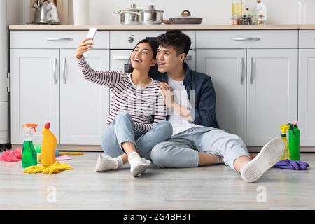 Müde asiatische Hausbesitzer, die Selfie machen, während sie sich ausruhen Stockfoto