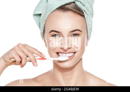 Schöne junge Frau mit perfektem Lächeln putzt ihre Zähne über weißen Hintergrund Studio-Aufnahme.. Zähneputzen, perfekte weiße Zähne, Zahnaufhellung c Stockfoto