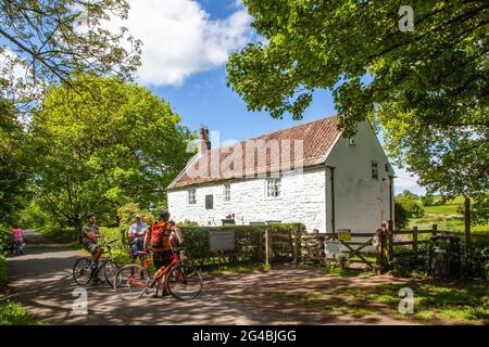 Radfahrer auf dem Wylam Wagonway vor dem Haus, das der Geburtsort des Bauingenieurs George Stephenson war, der die Dampflokomotive erfunden hat Stockfoto