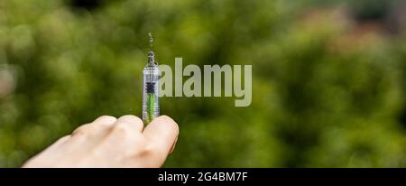 Hand halten Spritze mit Tropfen auf der Nadel. Banner, Breitformat Stockfoto
