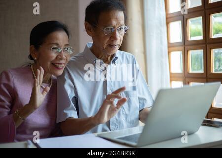 Asiatisches Senior-Paar mit Laptop-Computer für vdo-Anruf mit ihrer Familie.Lifestyle-Technologie-Gerät Konzept, schöne ältere Paar. Stockfoto