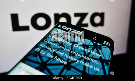 Mobiltelefon mit Website des Schweizer Chemieunternehmens Lonza Group AG auf dem Bildschirm vor dem Unternehmenslogo. Konzentrieren Sie sich auf die obere linke Seite des Telefondisplays. Stockfoto