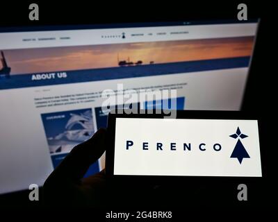 Person, die ein Smartphone mit dem Logo des anglo-französischen Öl- und Gasunternehmens Perenco S.A. auf dem Bildschirm vor der Website hält. Konzentrieren Sie sich auf die Telefonanzeige. Stockfoto