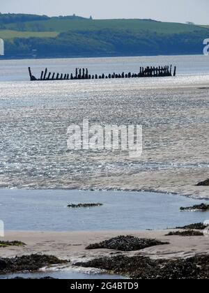 Dhoon Bay aka Goat Well Bay , in der Nähe von Kirkcudbright, Dumfries & Galloway, Schottland , zeigt das Wrack des Monreith aus dem nahe gelegenen Wigtown, das 1880 in Port William erbaut wurde. Am 12. November 1900 war sie auf einer Reise von Newcastle (Irland) nach Silloth mit Granitsteinkörner unterwegs. Während eines Sturms versuchte sie, sich in der Mündung der Kirkcudbright Bay zu schützen, aber sie scheiterte. Alle an Bord schafften es, sicher an Land zu kommen. -( Foto aufgenommen im Juni 2021) Stockfoto