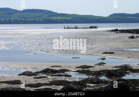 Dhoon Bay aka Goat Well Bay , in der Nähe von Kirkcudbright, Dumfries & Galloway, Schottland , zeigt das Wrack des Monreith aus dem nahe gelegenen Wigtown, das 1880 in Port William erbaut wurde. Am 12. November 1900 war sie auf einer Reise von Newcastle (Irland) nach Silloth mit Granitsteinkörner unterwegs. Während eines Sturms versuchte sie, sich in der Mündung der Kirkcudbright Bay zu schützen, aber sie scheiterte. Alle an Bord schafften es, sicher an Land zu kommen. -( Foto aufgenommen im Juni 2021) Stockfoto