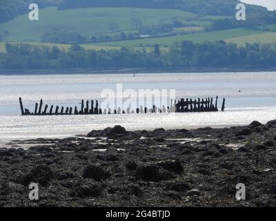 Dhoon Bay aka Goat Well Bay , in der Nähe von Kirkcudbright, Dumfries & Galloway, Schottland , zeigt das Wrack des Monreith aus dem nahe gelegenen Wigtown, das 1880 in Port William erbaut wurde. Am 12. November 1900 war sie auf einer Reise von Newcastle (Irland) nach Silloth mit Granitsteinkörner unterwegs. Während eines Sturms versuchte sie, sich in der Mündung der Kirkcudbright Bay zu schützen, aber sie scheiterte. Alle an Bord schafften es, sicher an Land zu kommen. -( Foto aufgenommen im Juni 2021) Stockfoto