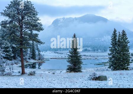 Snowy Mountain Lake - EINE verschneite Aussicht auf Sheep Lakes am Frühlingsabend, mit nebligen Deer Mountain im Hintergrund. Rocky Mountain National Park, Stockfoto