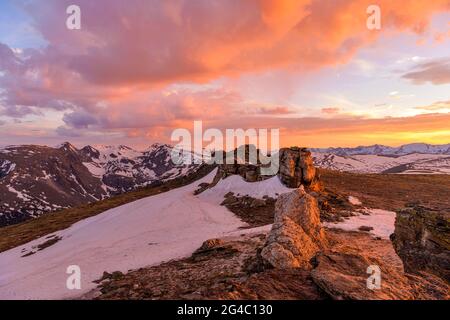 Sunset Mountain Top - farbenfrohe Frühlingswolken hängen über schneebedeckten hohen Gipfeln der Kontinentalscheide oben auf dem RMNP, Colorado, USA. Stockfoto