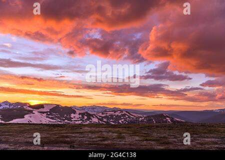 Spring Sunset at Top of Rockies - EIN Weitwinkelblick auf farbenfrohe Spring Sunset Clouds über schneebedeckten hohen Gipfeln der Continental Divide, RMNP, CO Stockfoto