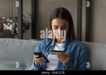 Glückliche junge Frau beim Einkaufen in der mobilen Anwendung. Stockfoto