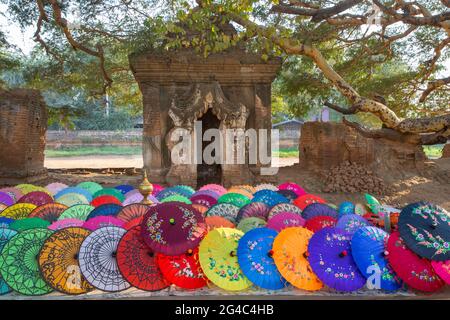 Farbenfrohe Regenschirme und Überreste historischer buddhistischer Tempel in Mandalay, Myanmar Stockfoto