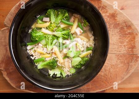 Ein Schuss hausgemachtes Hühnchen aus der Region mit farmfrischem Gemüse und Ramen-Nudeln Stockfoto