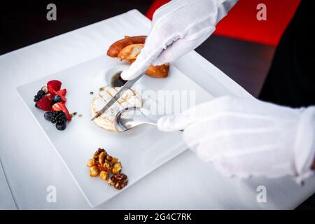 Gegrillter Camambert mit Beeren und Preiselbeersoße, serviert in einem Restaurant. Hospitality- und Catering-Service-Konzept Stockfoto